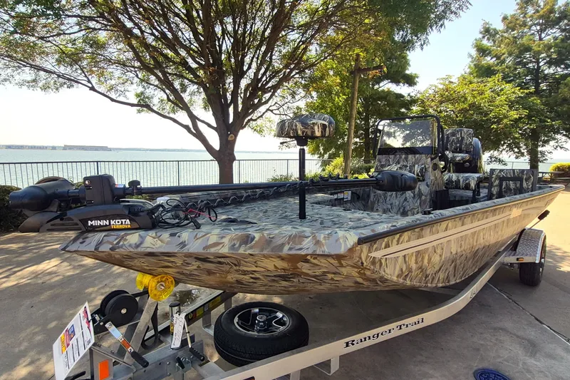 Slide: The Image of 2027 Ranger RB190 boat with camo design, equipped with Minn Kota Terrova motor, parked by a lakeside. - 2