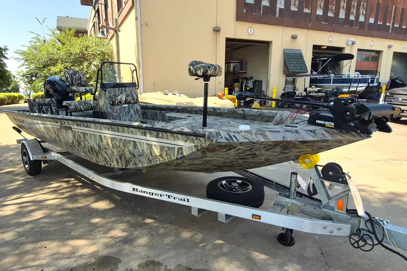 The Image of 2027 Ranger RB190 boat with camouflage design on a trailer, parked outdoors. - 0