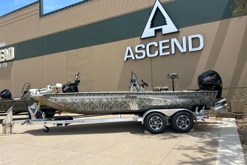 Slide: The Image of 2027 Ranger RB200 boat on trailer outside Ascend store, featuring camouflage design. - 14