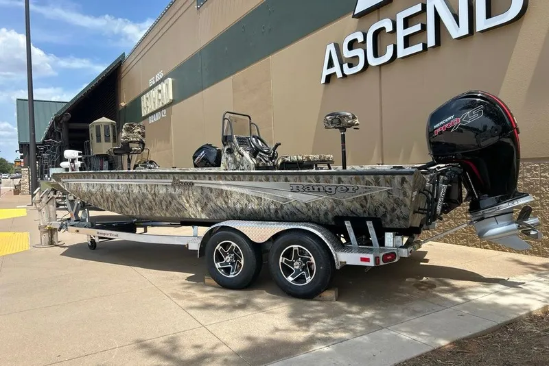 Slide: The Image of 2027 Ranger RB200 boat with camouflage design on a trailer outside a store. - 13