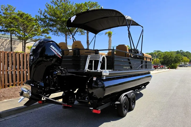 Slide: The Image of 2027 Ranger 220FC pontoon boat with Mercury engine on a trailer, parked outdoors. - 5