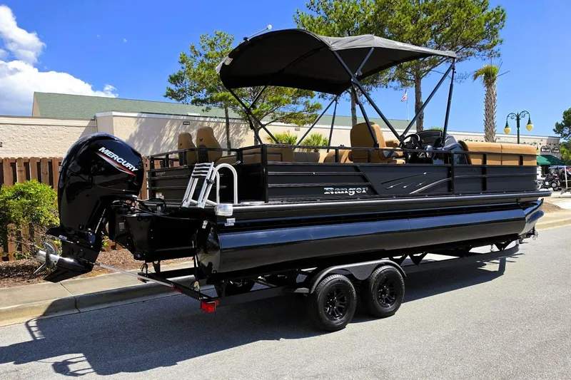 Slide: The Image of 2027 Ranger 220FC pontoon boat with Mercury outboard engine on a trailer, parked outdoors. - 3