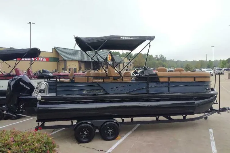 Slide: The Image of 2027 Ranger 223FC pontoon boat with canopy on trailer in parking lot. - 1