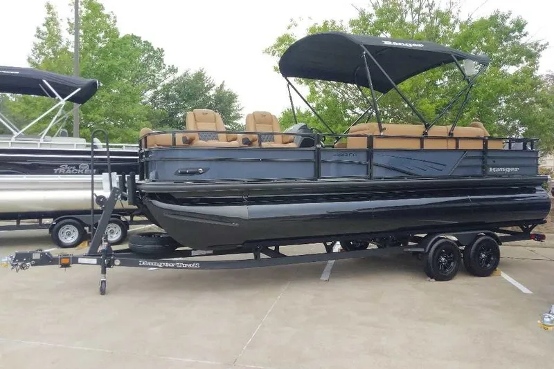 The Image of 2027 Ranger 223FC pontoon boat with canopy on trailer, parked outdoors. - 0