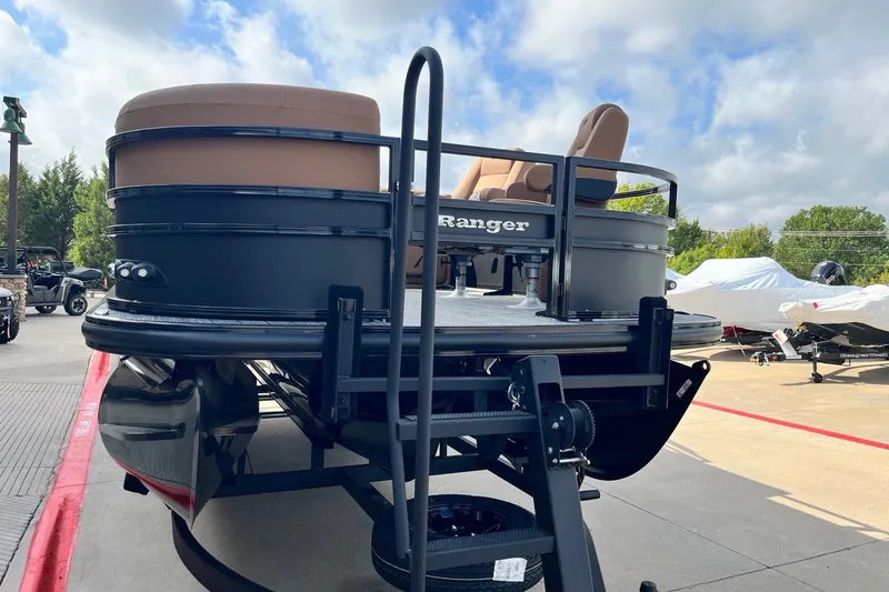 Slide: The Image of 2027 Ranger 223FC pontoon boat with tan seating, displayed outdoors under a cloudy sky. - 9