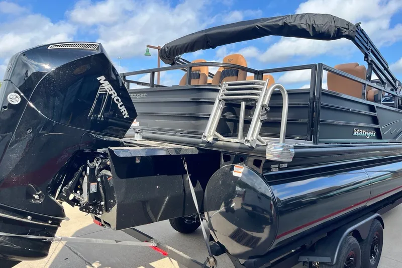 Slide: The Image of 2027 Ranger 223FC boat with Mercury engine, black exterior, and ladder, under a blue sky. - 6