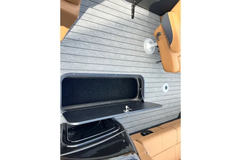 Slide: The Image of 2027 Ranger 223FC boat interior with tan seats and storage compartment. - 7