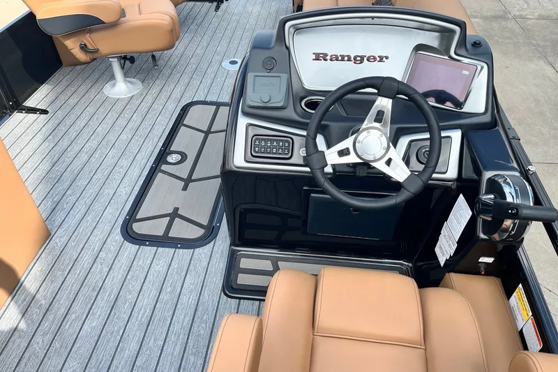 Slide: The Image of 2027 Ranger 223FC boat interior with steering wheel, control panel, and tan seating. - 8