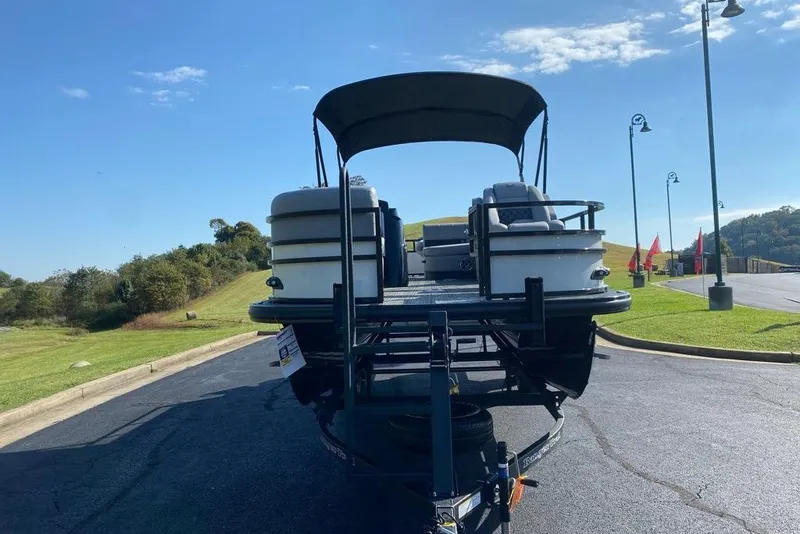 Slide: The Image of 2027 Ranger 220FC boat on trailer, parked on sunny road with green landscape. - 2