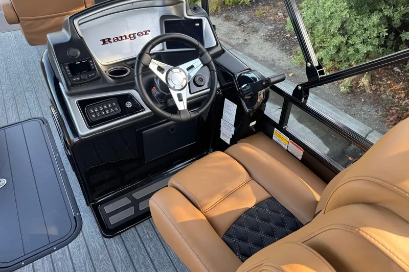 Slide: The Image of 2027 Ranger 223F boat interior with steering wheel and tan leather seating. - 12