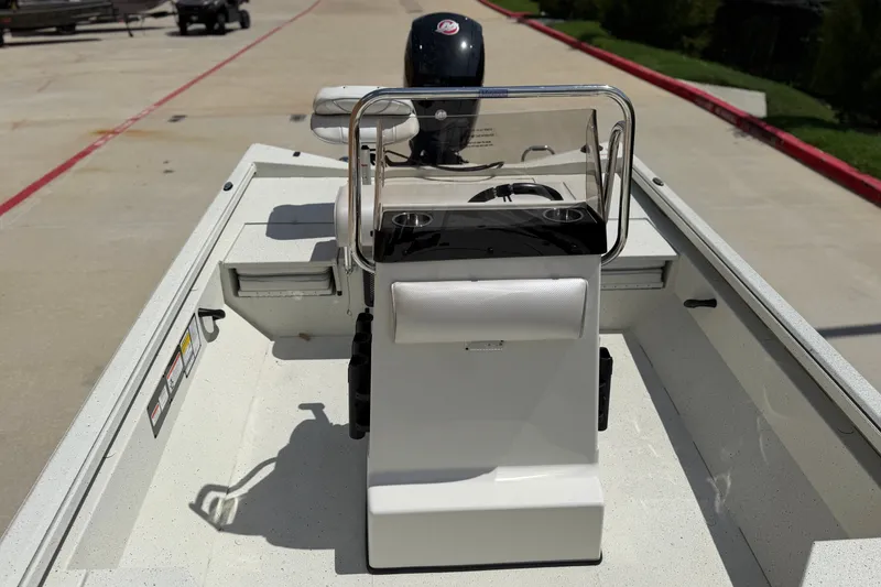 Slide: The Image of 2027 Ranger RB200 boat interior with steering console and seating, parked on concrete. - 9