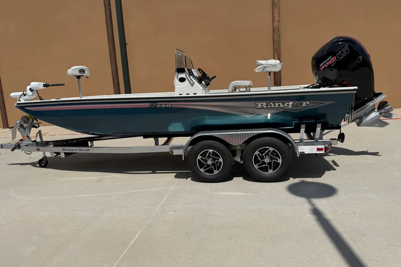 Slide: The Image of 2027 Ranger RB200 boat on trailer, teal color, dual axle, outdoor setting. - 1