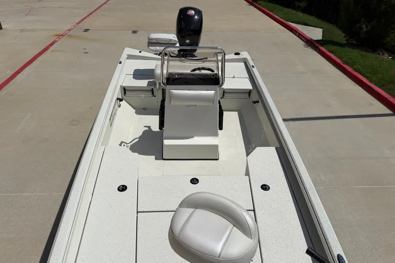 Slide: The Image of 2027 Ranger RB200 boat interior with steering console and seating, parked on concrete. - 10