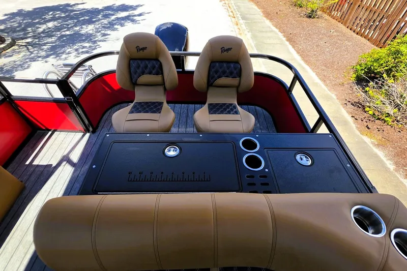 Slide: The Image of 2027 Ranger 223FC boat interior with tan seats, cup holders, and storage compartments. - 18