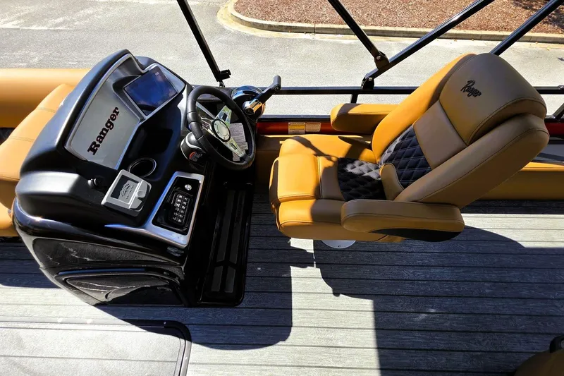 Slide: The Image of Captain's seat and console of 2027 Ranger 223FC boat, featuring modern controls and luxurious seating. - 15