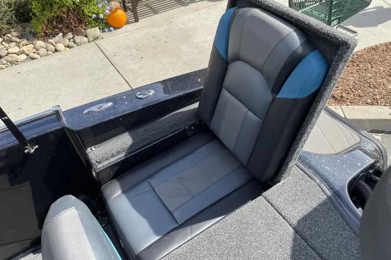 Slide: The Image of 2027 Nitro ZV19 Sport boat seat with gray and blue upholstery, parked on concrete. - 28