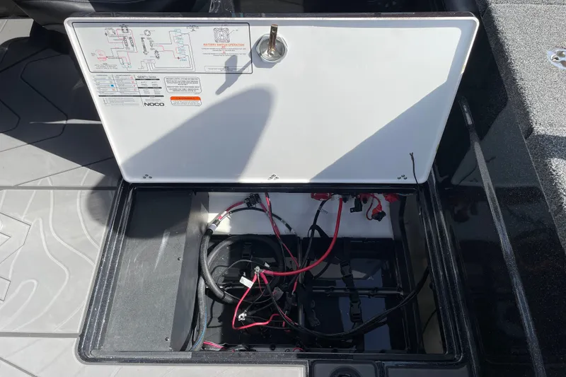 Slide: The Image of Open battery compartment of 2027 Nitro ZV19 Sport boat, showing wiring and connections. - 26