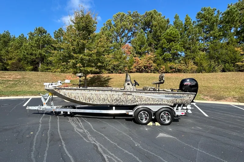 Slide: The Image of 2027 Ranger RB200 boat on trailer in parking lot, surrounded by trees. - 1