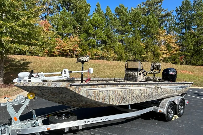 Slide: The Image of 2027 Ranger RB200 boat with camouflage design on a trailer, surrounded by trees. - 3