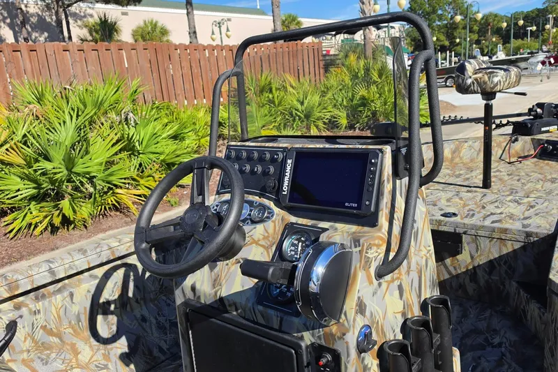 Slide: The Image of 2027 Ranger RB190 boat dashboard with steering wheel, Lowrance Elite display, and camo design. - 15