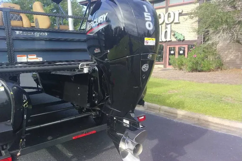 Slide: The Image of 2027 Ranger 220FC boat with Mercury 150 outboard motor, parked near a building. - 12