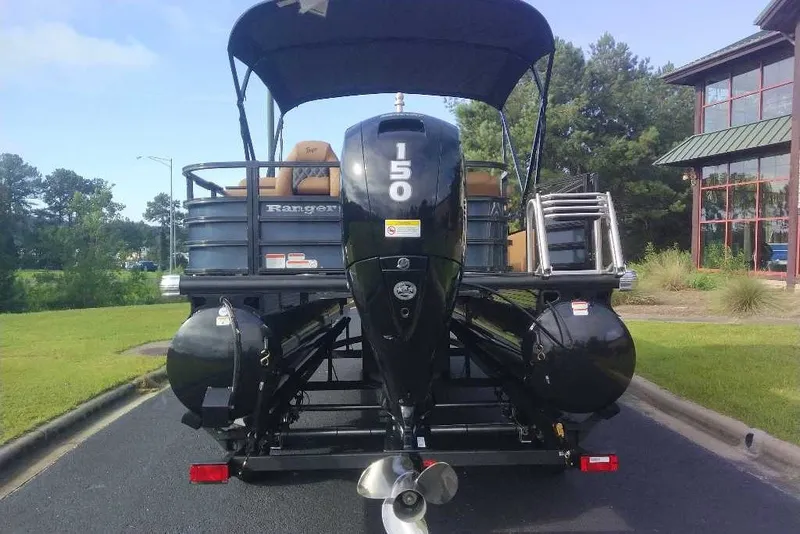 Slide: The Image of 2027 Ranger 220FC pontoon boat with 150 HP engine, parked outdoors. - 13