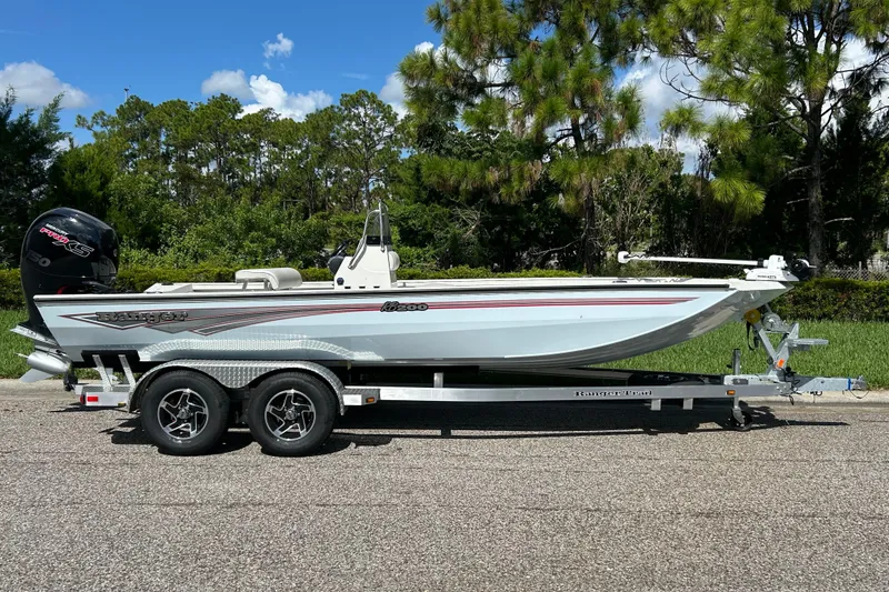 Slide: The Image of 2027 Ranger RB200 boat on trailer, parked on road with lush greenery background. - 1