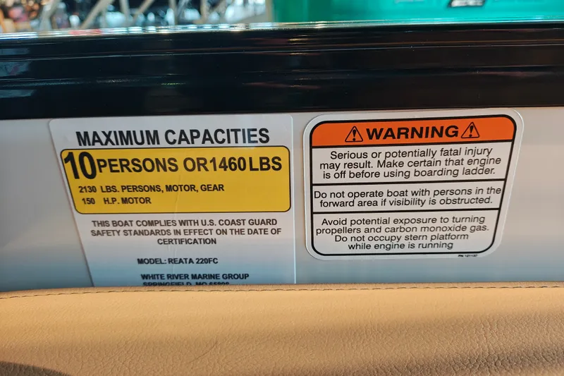 Slide: The Image of Warning and capacity labels on a 2027 Ranger 220FC boat, detailing safety and weight limits. - 33