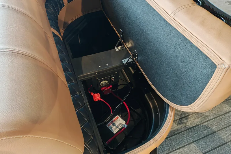 Slide: The Image of Open storage compartment in 2027 Ranger 220FC boat with visible wiring and battery. - 44