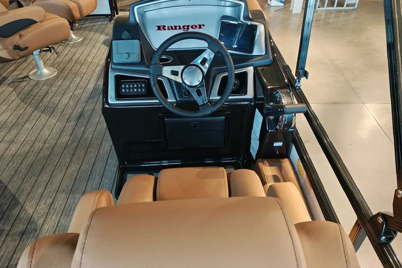 Slide: The Image of 2027 Ranger 220FC boat interior with steering wheel and tan seating. - 23