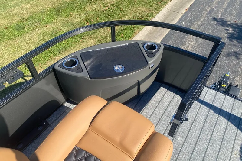 Slide: The Image of 2027 Ranger 223F boat interior with tan seats and cup holders on a sunny day. - 9