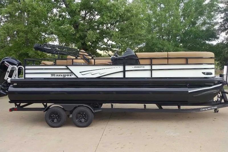 Slide: The Image of 2027 Ranger 220FC pontoon boat on trailer, parked outdoors. - 10