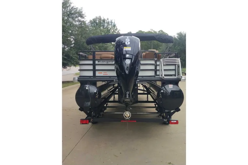 Slide: The Image of 2027 Ranger 220FC pontoon boat with powerful outboard motor, parked on a trailer. - 8