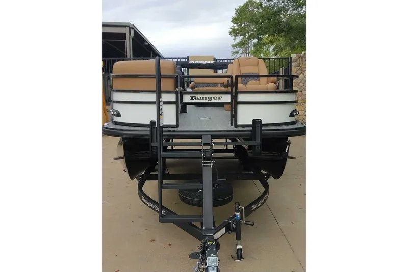 Slide: The Image of 2027 Ranger 220FC pontoon boat on trailer, featuring tan seating and sleek design. - 12