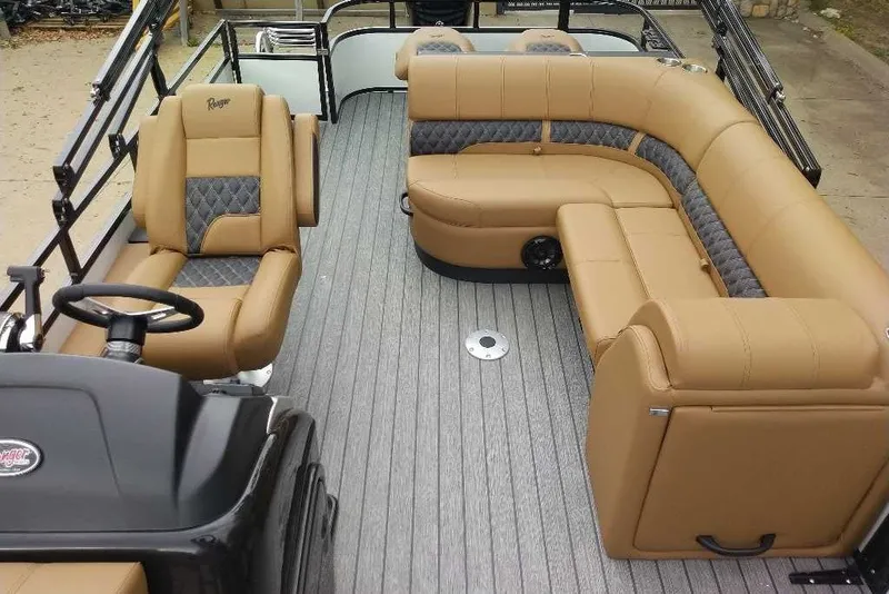 Slide: The Image of 2027 Ranger 220FC boat interior with tan and gray seating, steering console, and spacious layout. - 6