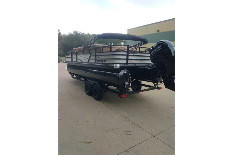 Slide: The Image of 2027 Ranger 220FC pontoon boat on trailer, parked outdoors. - 9