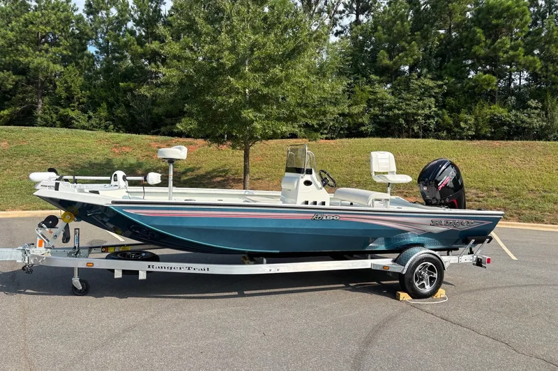 Slide: The Image of 2027 Ranger RB190 boat on trailer, parked outdoors with trees in background. - 3