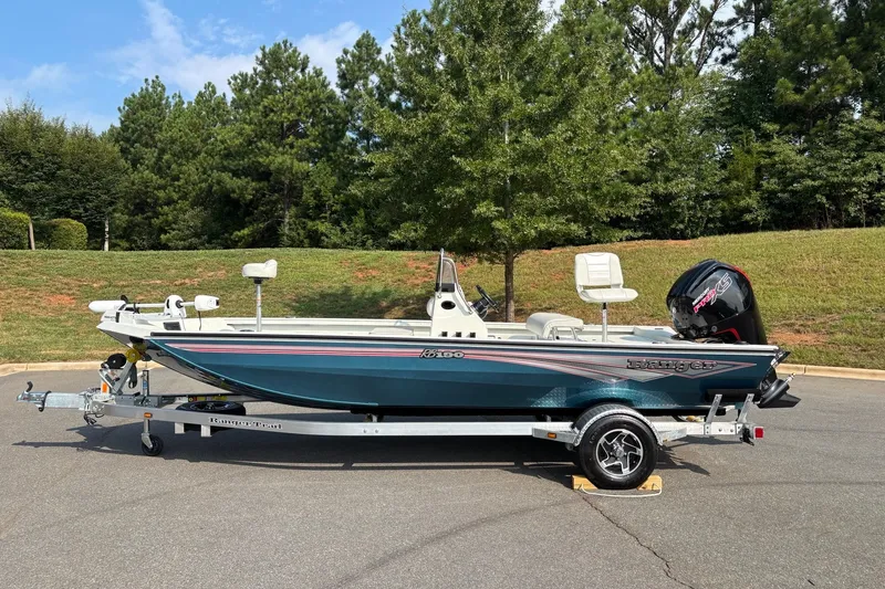 Slide: The Image of 2027 Ranger RB190 boat on trailer, parked outdoors with trees in background. - 1