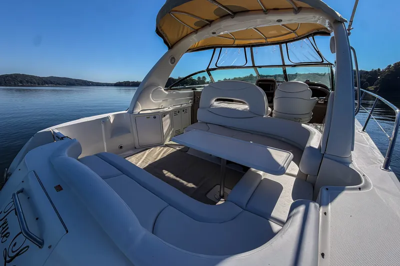 Slide: The Image of 2003 Sea Ray 410 Sundancer yacht interior with seating and table on calm water. - 30