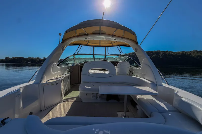 Slide: The Image of 2003 Sea Ray 410 Sundancer yacht interior with seating, table, and canopy on a sunny day. - 29