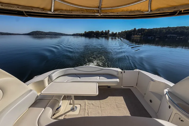 Slide: The Image of 2003 Sea Ray 410 Sundancer cruising on a serene lake with clear skies. - 17