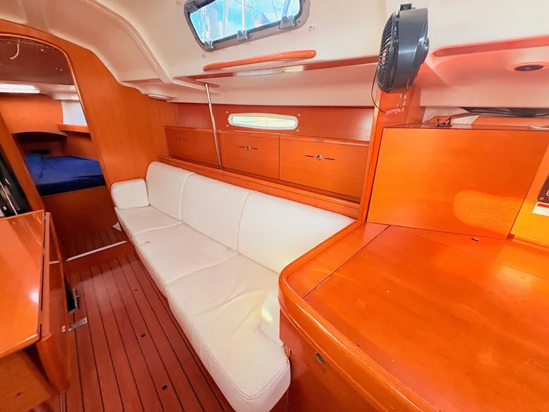 Slide: The Image of Interior of a 2007 Beneteau First 36.7 with wooden furnishings and a white sofa. - 15