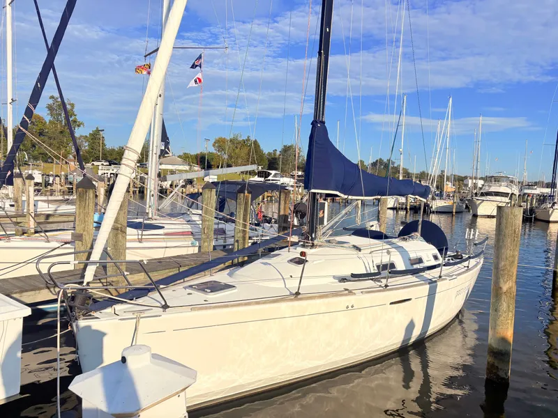 Slide: The Image of A 2007 Beneteau First 36.7 docked in a marina, featuring a blue sail cover. - 1