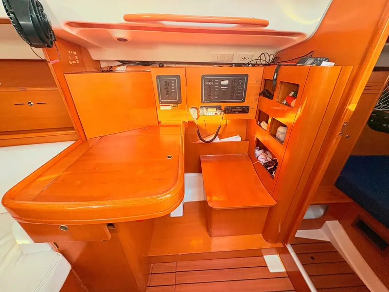 Slide: The Image of Interior of a 2007 Beneteau First 36.7 with wooden furnishings and navigation equipment. - 14