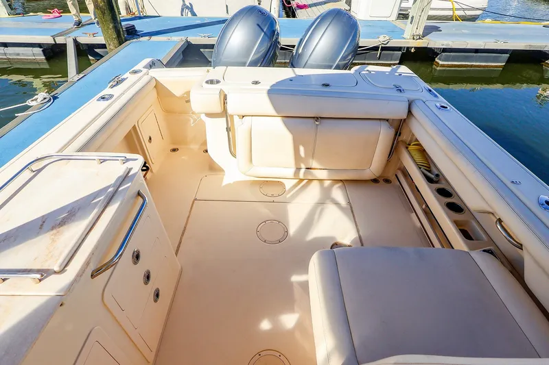 Slide: The Image of 2016 Grady-White Freedom 275 boat interior with seating and storage, docked at marina. - 18