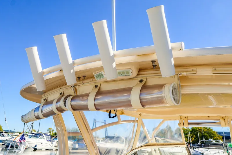 Slide: The Image of 2016 Grady-White Freedom 275 boat with rod holders and clear enclosure, docked under blue sky. - 27