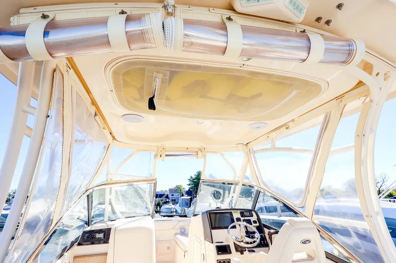 Slide: The Image of 2016 Grady-White Freedom 275 boat interior with helm, clear canopy, and modern controls. - 26