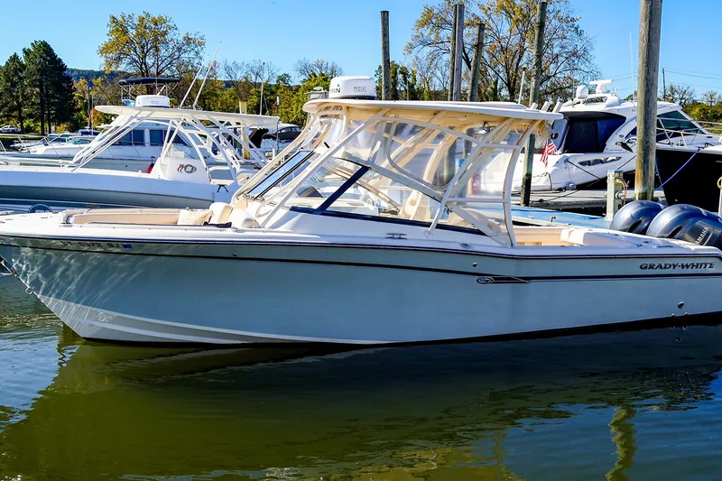 The Image of 2016 Grady-White Freedom 275 boat docked in a marina under clear blue skies. - 1