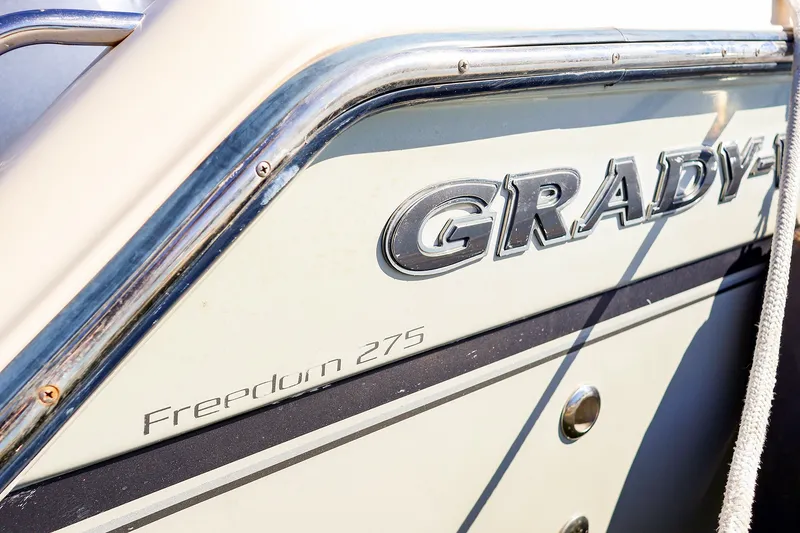 Slide: The Image of 2016 Grady-White Freedom 275 boat side view with logo and chrome details. - 32