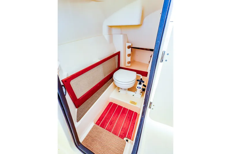Slide: The Image of 2016 Grady-White Freedom 275 boat interior with compact marine toilet and storage space. - 29